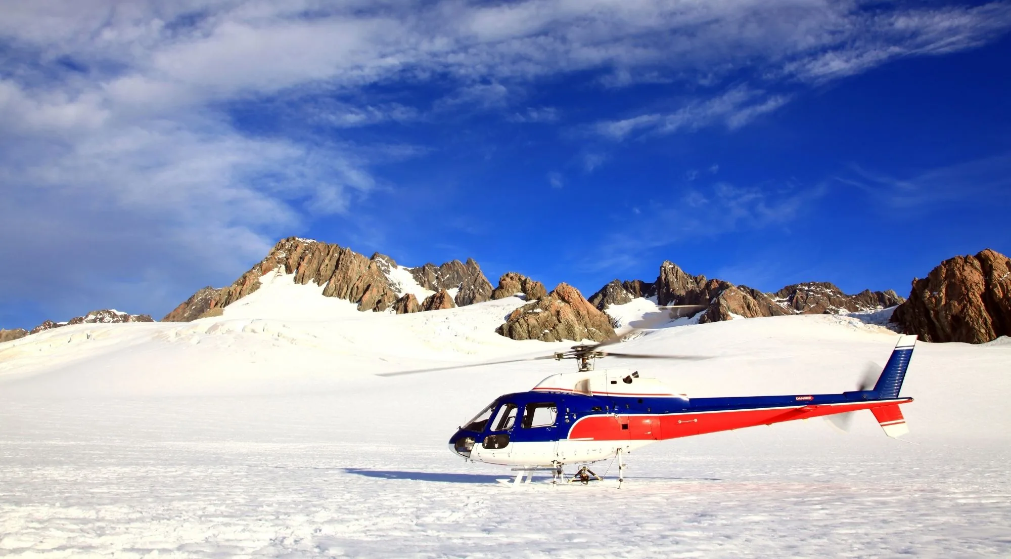 Scenic helicopter parked on a snowfield after a glacier landing