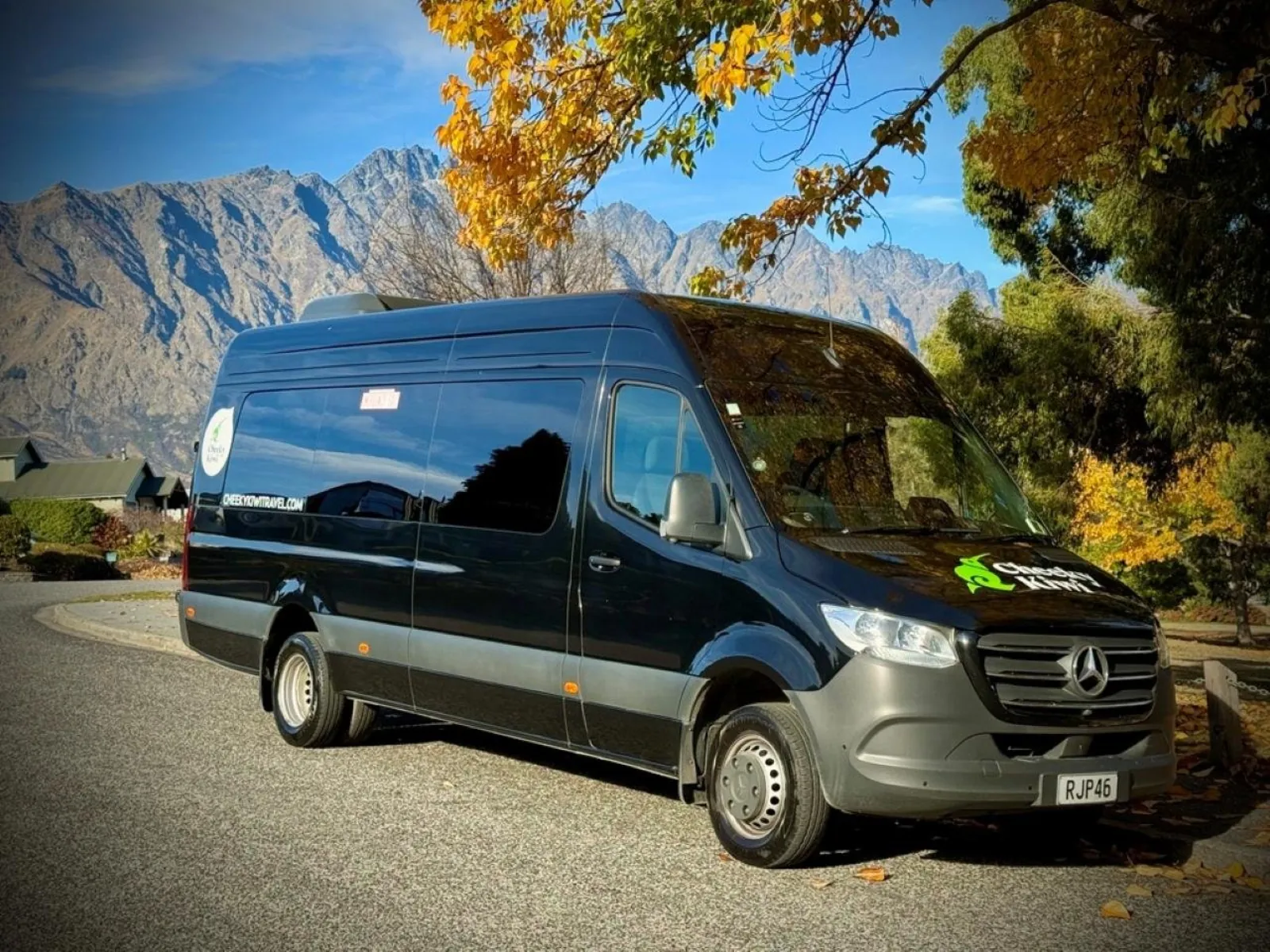Black Cheeky Kiwi Mercedes Sprinter parked in Queenstown with The Remarkables behind