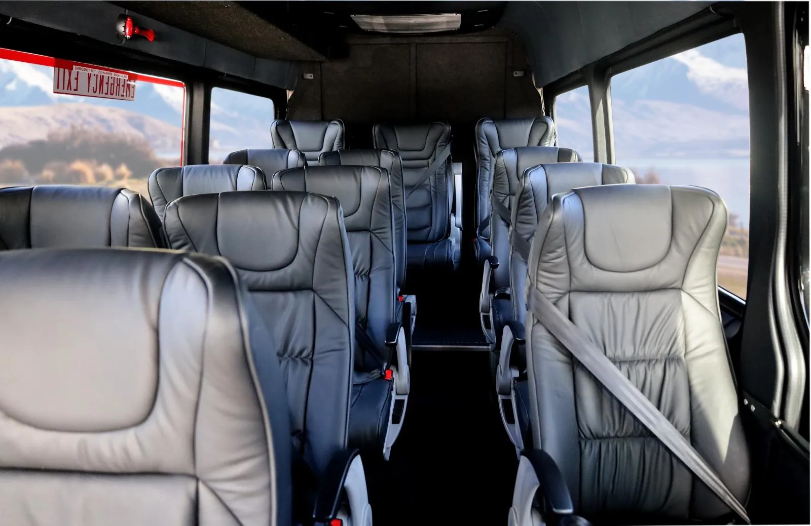 Rows of leather seats and large windows inside the tour minibus