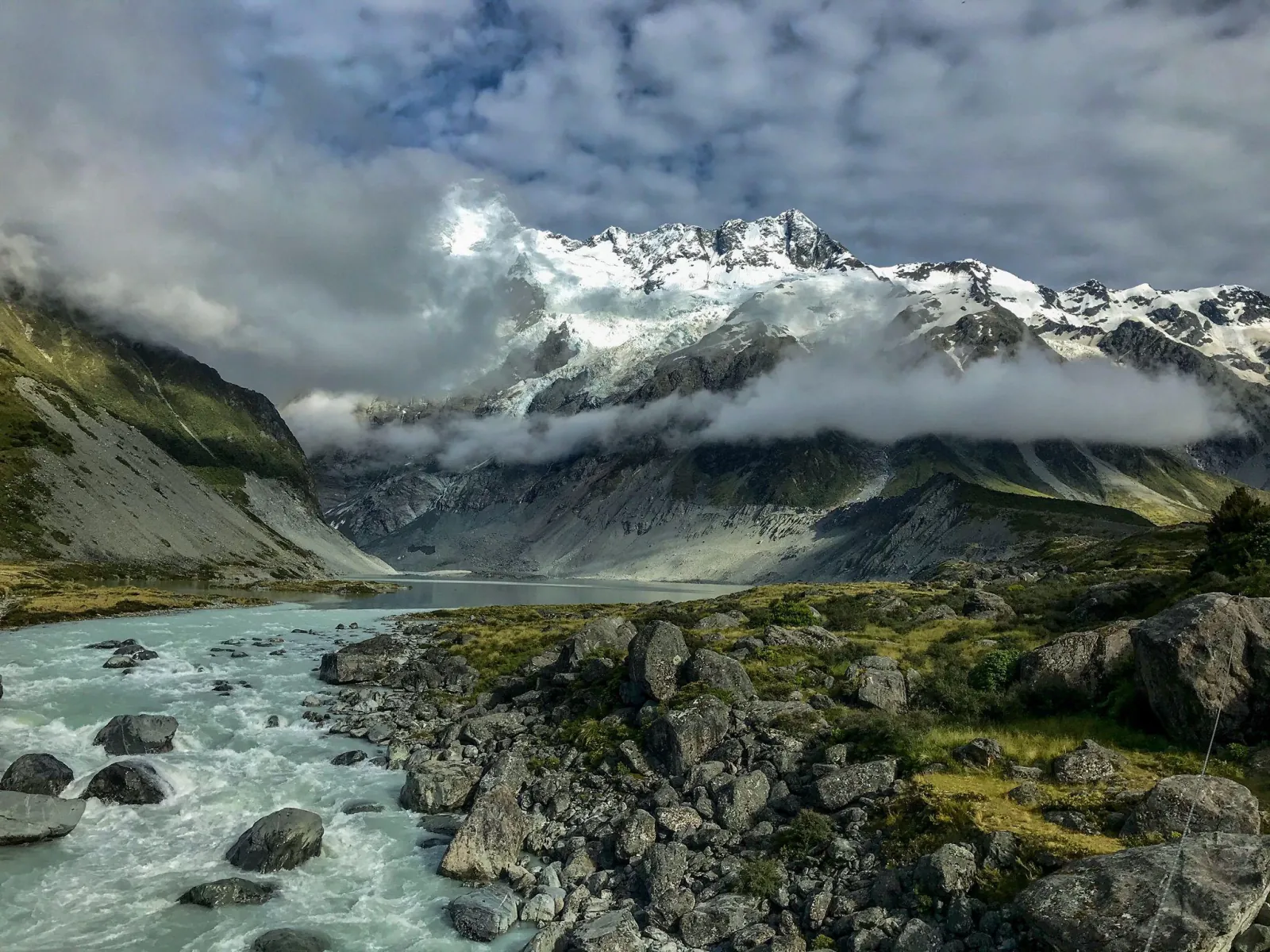 Glacial river and lake beneath snowy Mount Sefton in the Hooker Valley under low cloud