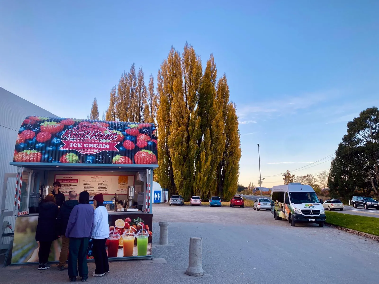 Real fruit ice cream stand and autumn poplars at Jackson Orchards, with the tour minibus parked nearby