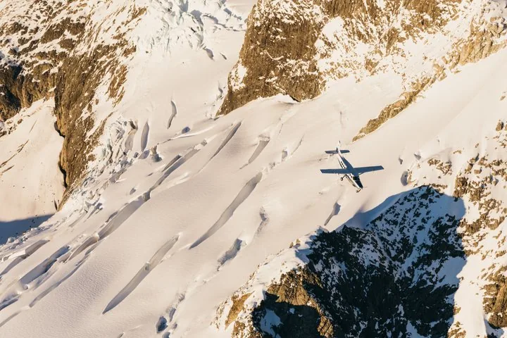 Light plane flying over crevassed snowfields in the Southern Alps