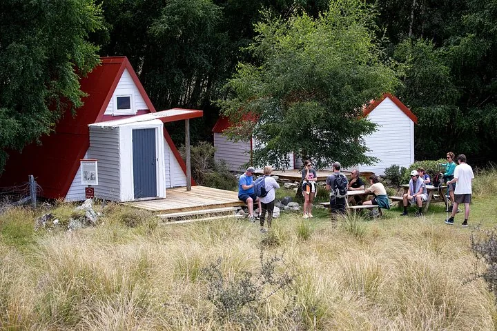Guests at picnic tables outside the red-roofed huts of the Glentanner historic field station