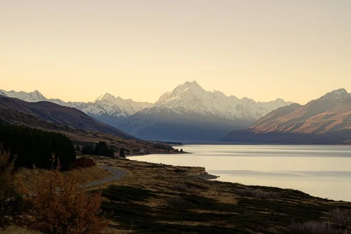 Lake Pūkaki and Aoraki/Mount Cook at dusk, the highway winding along the shore